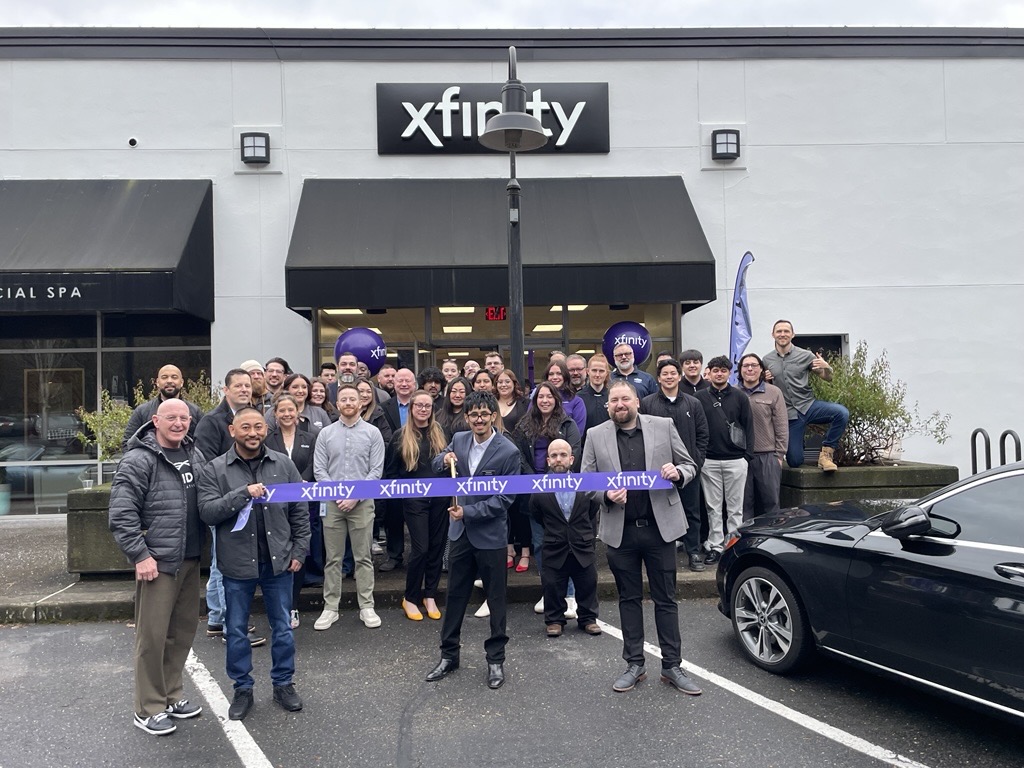 A large group of Xfinity team member in front of an Xfinity Store during a ribbon cutting ceremony.